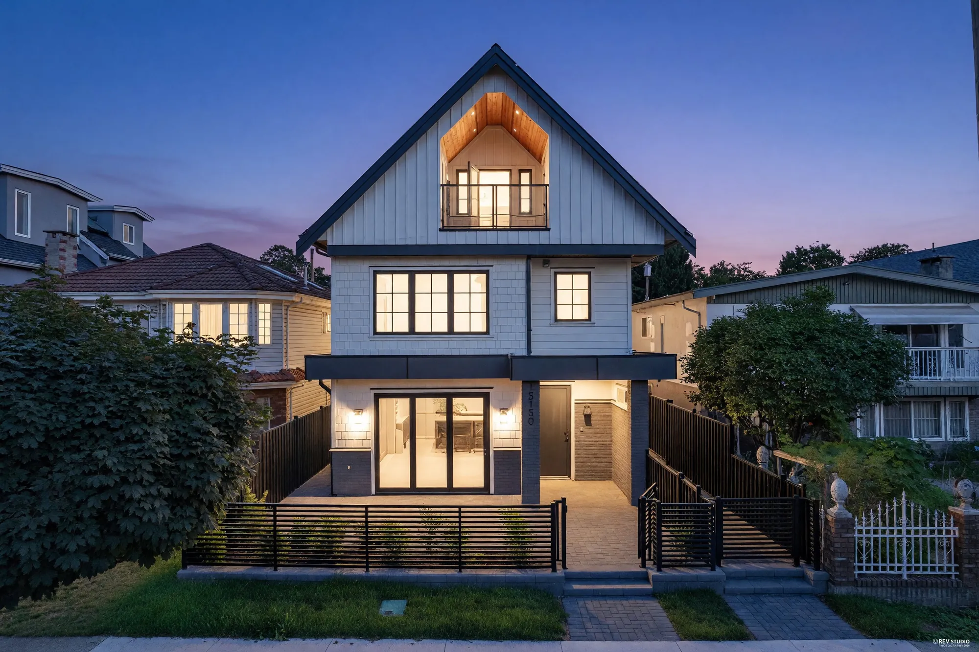 The house from the air at dusk, the whole front elevation lit