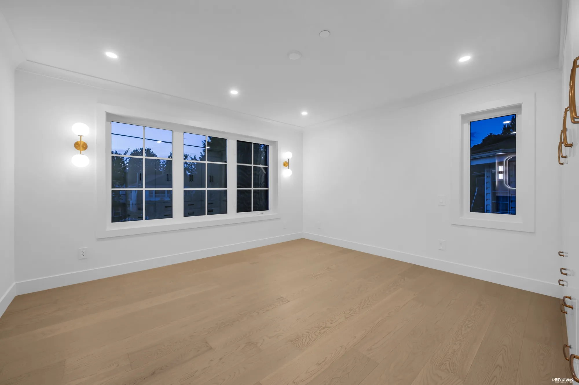 Bedroom with windows on two walls and wall sconces