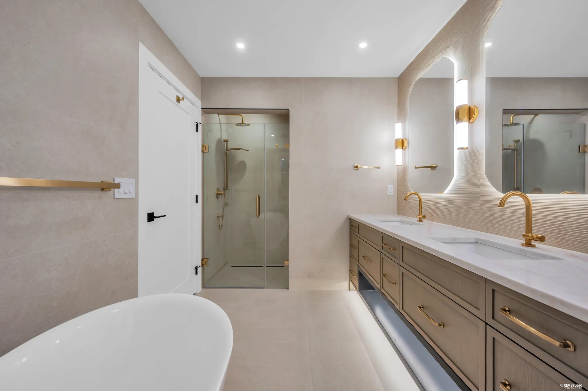 The same bathroom showing the glass shower and brass fittings