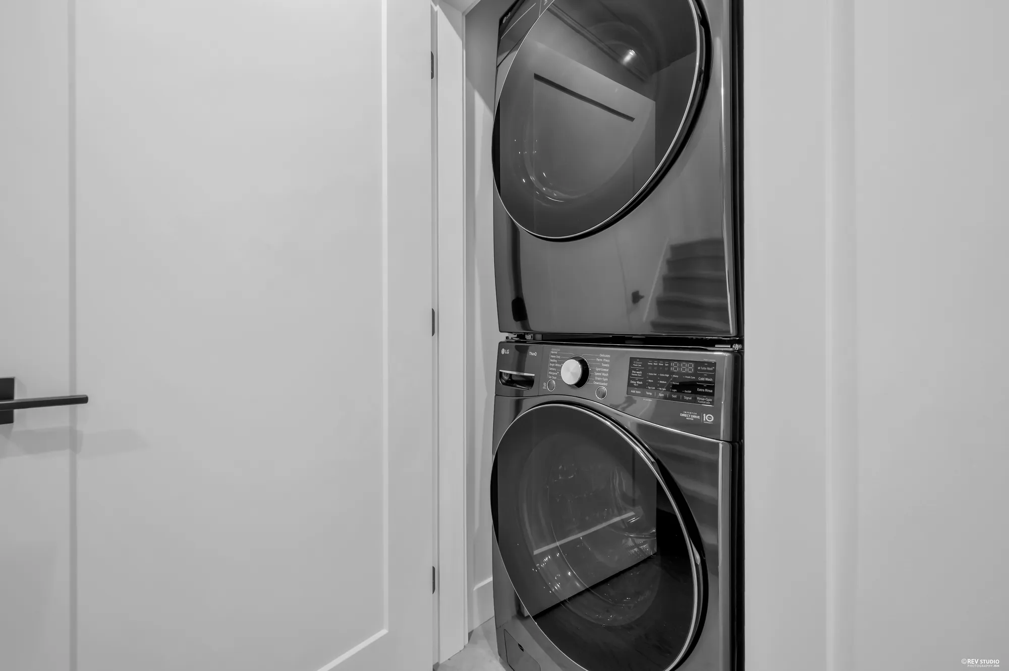 Stacked washer and dryer in a cupboard off the hall